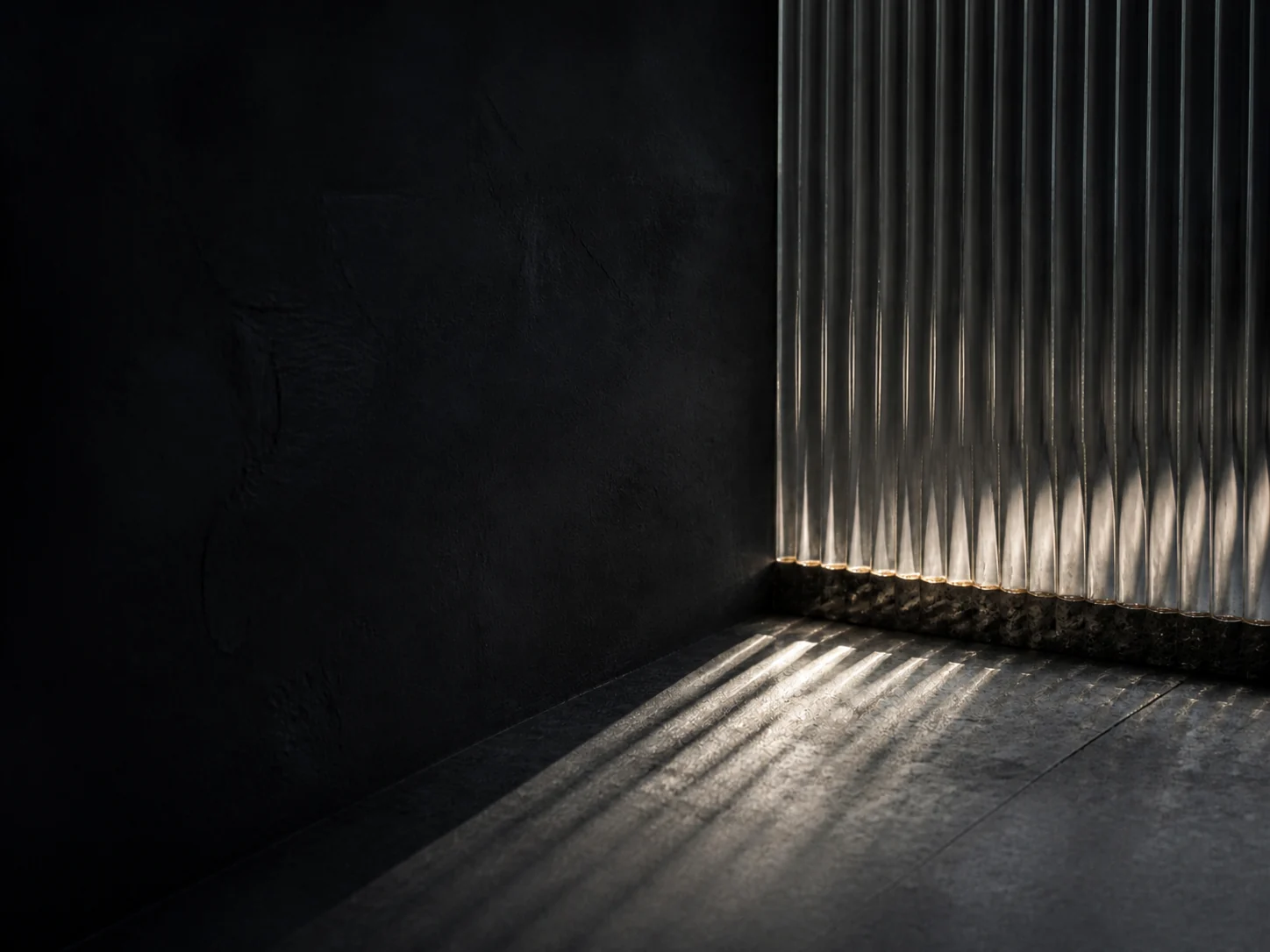 Daylight passing through a fluted screen into a dark interior